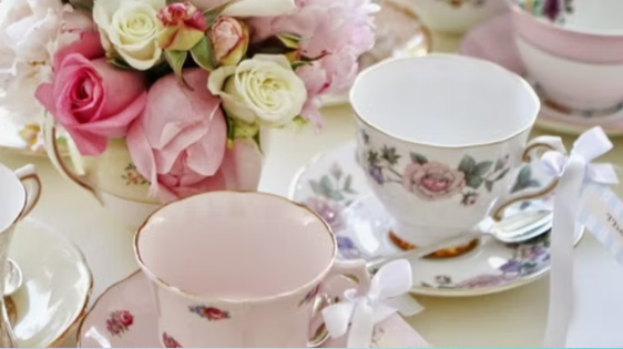 Vintage Tea Party Rentals Vintage tea cups and saucers beautifully arranged next to a bouquet.